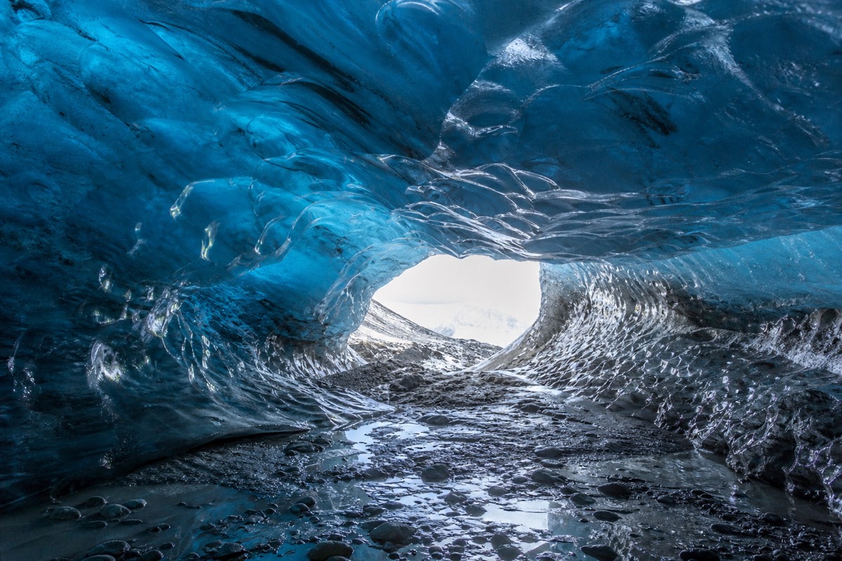 Inside a natural blue glacier ice cave, one of the activities adding to Iceland travel costs