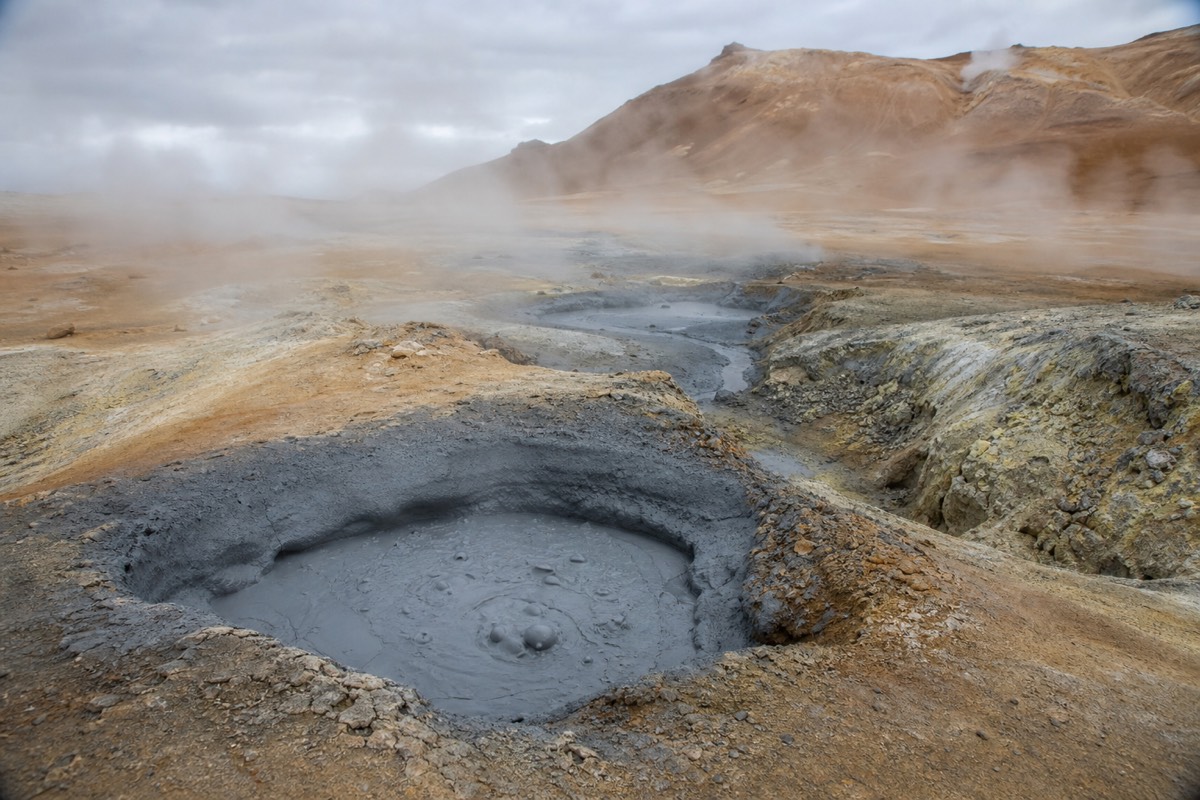 Steaming mud pots near the nature baths, a classic sight at Icelandic geothermal hot springs in the north