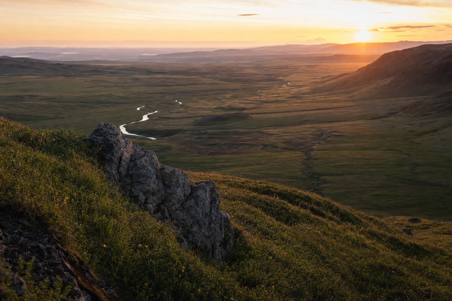 The midnight sun low over the Icelandic horizon during the best time to visit Iceland for daylight